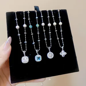 Detailed view of silver zircon necklaces with geometric flower pendants on black velvet