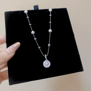 Detailed macro view of a silver pearl necklace with a star zircon pendant on black velvet