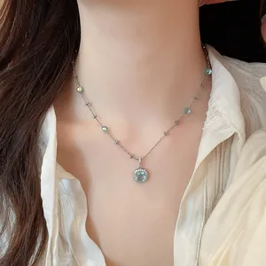 Close-up of elegant silver necklace featuring a light blue square zircon pendant on model.
