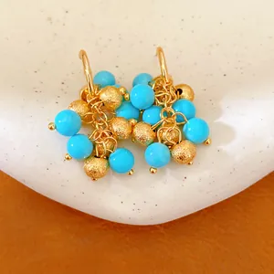 Detailed macro shot of vintage 18k gold plated earrings with blue resin bead clusters