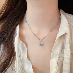 Detail of silver necklace with a square blue zircon pendant worn on the neck