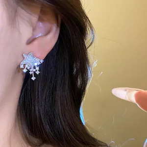 Detailed close-up of elegant silver star-shaped stud earrings featuring sparkling crystals