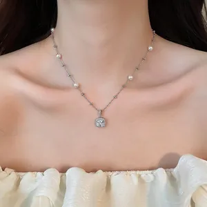 Detail shot of a silver zircon pendant necklace with pearls on an Asian model.