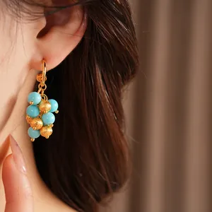 Close-up of vintage 18k gold plated earrings with blue and gold resin beads