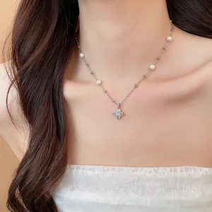 Close-up detail of a delicate flower zircon pendant necklace with pearls on a model