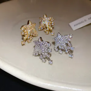 Close-up of sparkling star-shaped stud earrings with dangling crystal accents