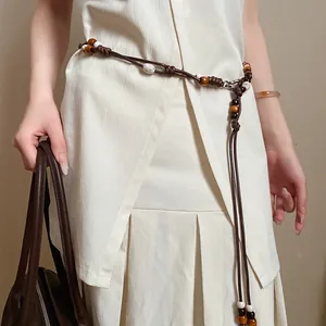 Macro detail of vintage ethnic waist chain featuring leather cord and wooden beads