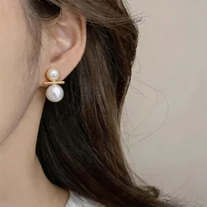 Primo piano laterale dettagliato di eleganti orecchini a perno con perle in oro 18k