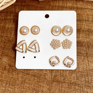 Detailed view of a 5-pair set of elegant pearl and geometric gold-tone stud earrings
