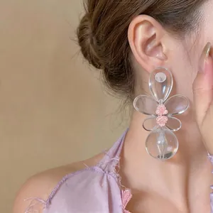 Elegantes pendientes de flores de resina transparente con detalles de rosas en modelo