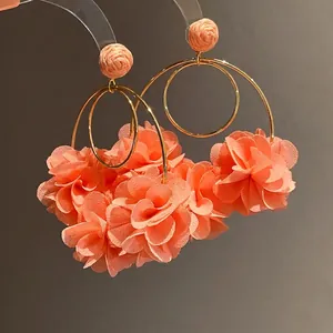 Elegant peach chiffon flower and raffia hoop earrings featuring gold metallic rings