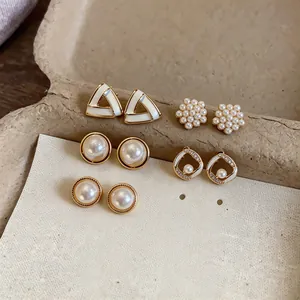 Elegant set of five pairs of geometric pearl stud earrings with delicate gold accents