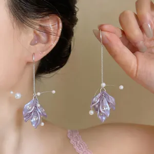 Detailed view of elegant purple petal earrings featuring rhinestones and white pearls