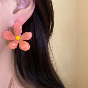 Vibrant pink resin flower stud earrings with silver needles and yellow center dopamine style