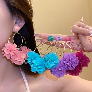Close-up detail of multi-colored chiffon flower hoop earrings in a sweet vacation style