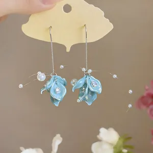 Close-up of elegant teal flower petal earrings with zircon and small pearls