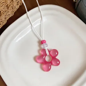 Gros plan détaillé d'un pendentif fleur en résine rose sur un collier en cuir blanc élégant