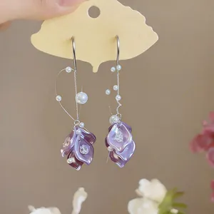 Detailed view of elegant purple petal earrings decorated with pearls and zircons.