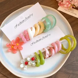 Colorful resin hoop and flower earring set displayed on jewelry cards