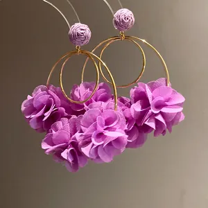 Detailed macro view of purple chiffon flower hoop earrings with elegant gold accents