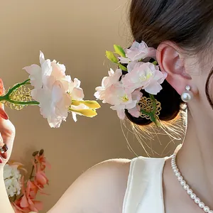 Primo piano di un'elegante molletta per capelli a fiore in tessuto rosa su una modella.