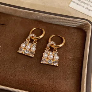 Dettaglio macro di eleganti orecchini a cerchio a forma di borsa con perle e cristalli
