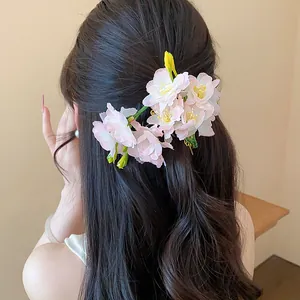 Vista dettagliata della clip per capelli con fiori di stoffa rosa su capelli lunghi