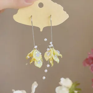 Close-up detail of Korean style yellow petal tassel earrings with pearls and zircon