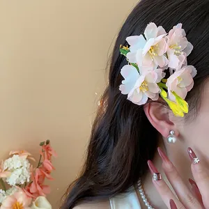 Dettaglio di una elegante molletta per capelli con fiori di ciliegio in tessuto rosa.