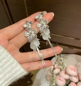 Macro view of exquisite silver zircon flower earrings with delicate white petals and tassels