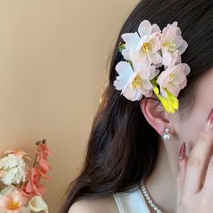 Primo piano di fermagli per capelli a forma di fiori di ciliegio in tessuto rosa.