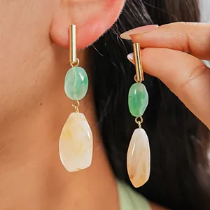 Elegant resin drop earrings with green and marble cream stones shown on a model.