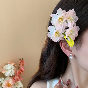 Primo piano di un elegante fermaglio per capelli in tessuto a fiori di ciliegio rosa su modella