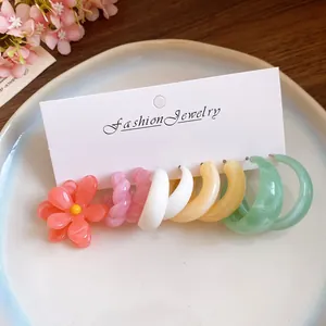 Detailed macro view of vibrant resin earring collection displayed on a white holder