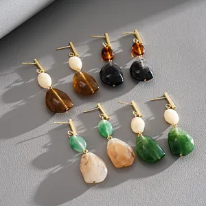 A diverse collection of vintage resin geometric drop earrings in stone-like finishes.