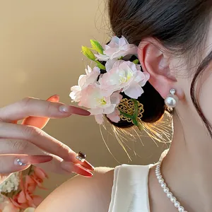Dettaglio ravvicinato di un elegante fermaglio con fiori in tessuto rosa e filigrana dorata