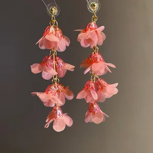 Close-up of pink fabric flower tassel earrings with layered organza petals