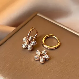 Close-up of 14k gold plated hoop earrings with detachable zircon flower charms