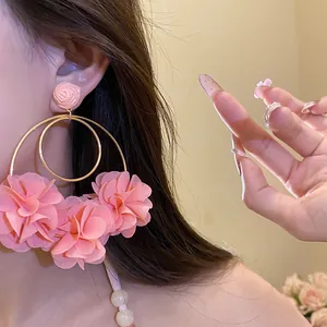Close-up detail of pink chiffon flower hoop earrings with elegant gold-tone hoops
