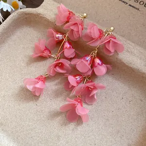Detailed shot of pink fabric flower petal drop earrings in a sweet bohemian style
