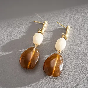 Close-up detail of vintage resin drop earrings with amber and cream beads