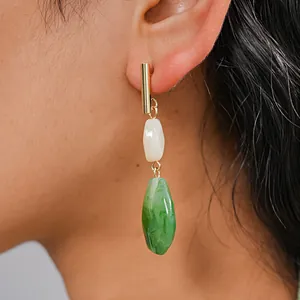 Detailed close-up of vintage resin drop earring with green marble effect on model