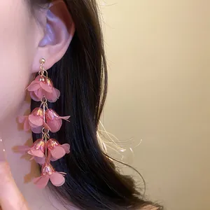 Detailed close-up showing the pink floral tassel earrings for a bohemian vacation style