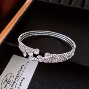 Detail view of a luxury vintage-style silver open bangle with clear rhinestones.