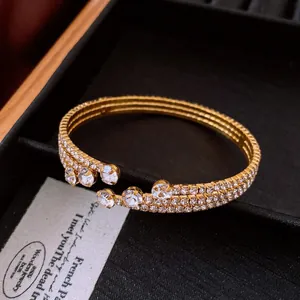 Close-up of a vintage gold-tone elastic open bangle with multi-row rhinestone inlay