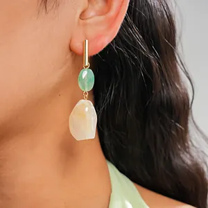 Close-up view of vintage resin drop earrings with green and cream colored geometric stones