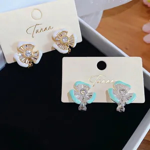 Detailansicht von 18k vergoldeten Blumen-Ohrclips mit funkelnden Zirkonia-Steinen