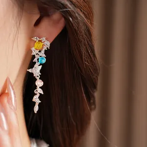 Close-up view of elegant zircon leaf tassel earrings worn on model's ear for detail