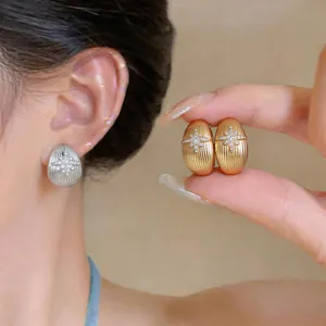 Gros plan détaillé de boucles d'oreilles goutte d'eau or et argent avec motif étoile
