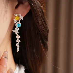 Detail view of silver needle leaf tassel earrings with colorful zircons and stones